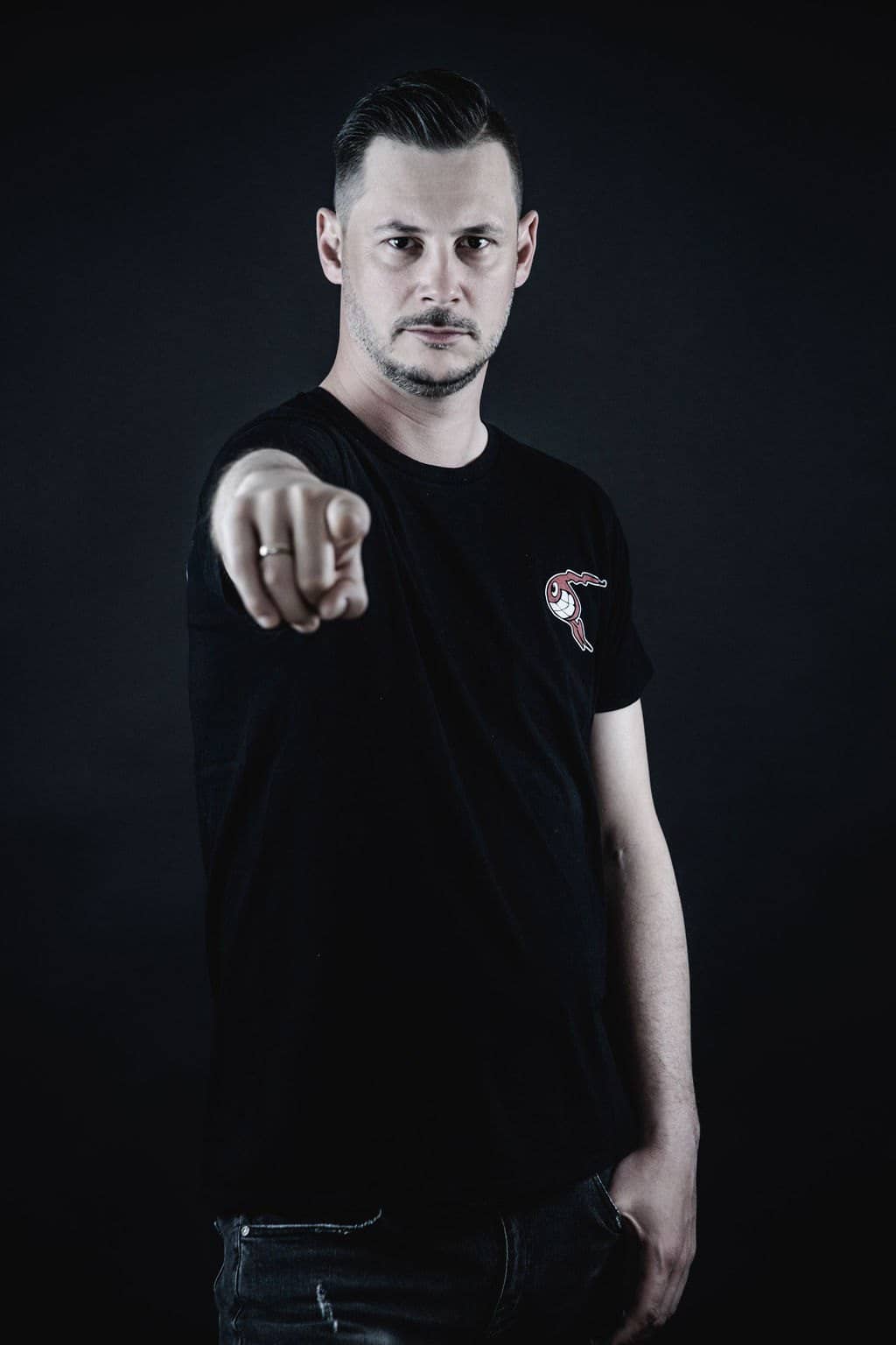 Stefan Rader von NOVUM im schwarzen Shirt vor dunklem Hintergrund